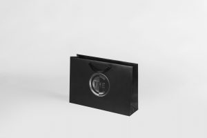 Czarna niska torebka papierowa z tłoczonym logotypem